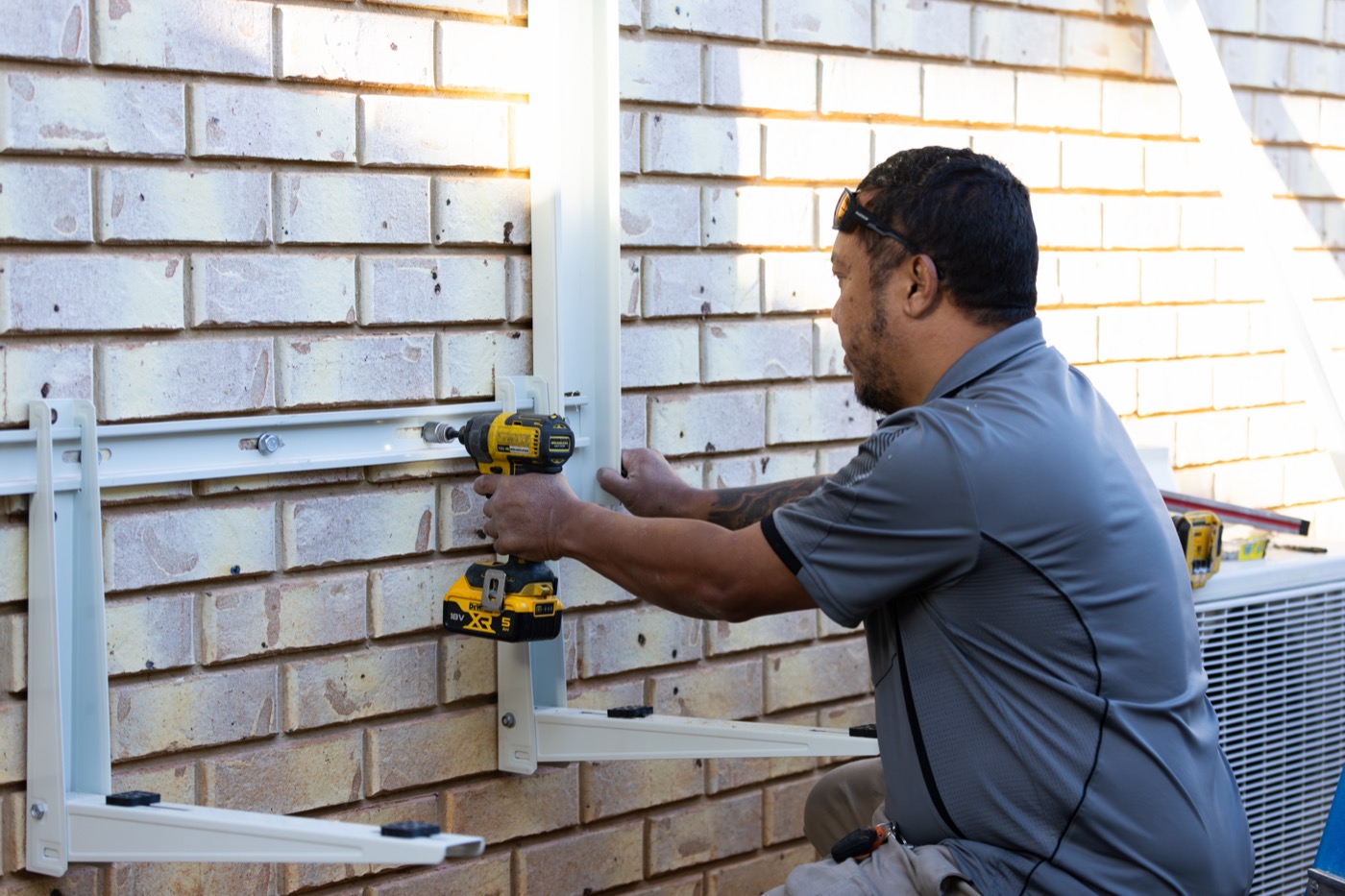 Technician installing a split system outdoor unit